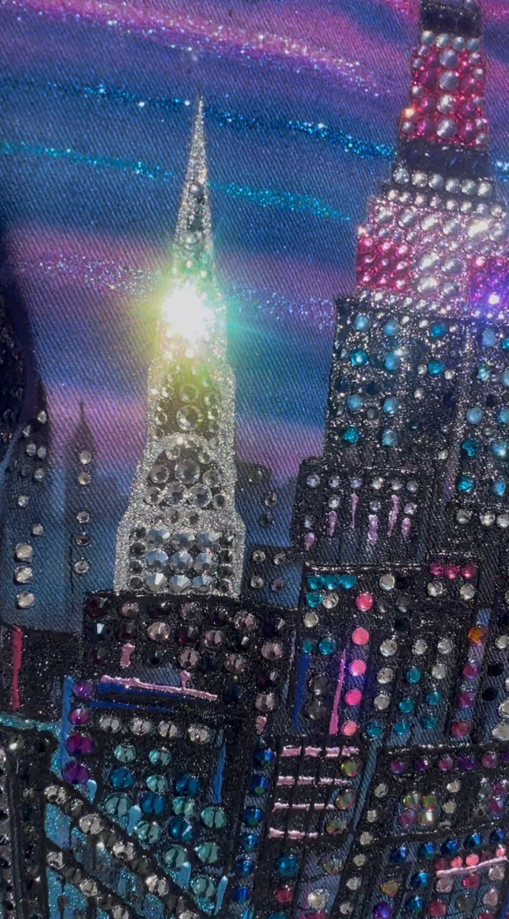 Decorative fabric with Loria NYC Art cityscape pattern featuring tall buildings and bright lights.