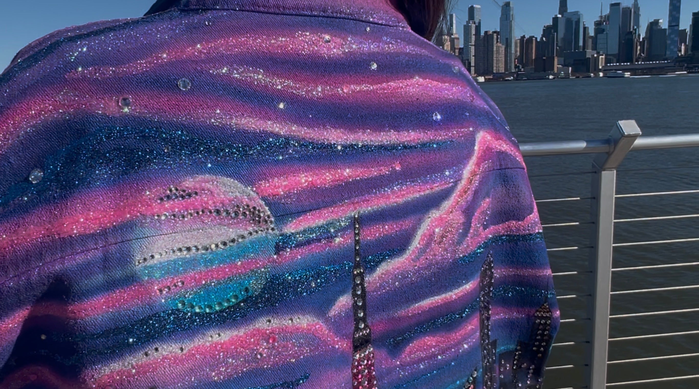 Person wearing a shirt with a Loria NYC Art design, standing in front of a city skyline.