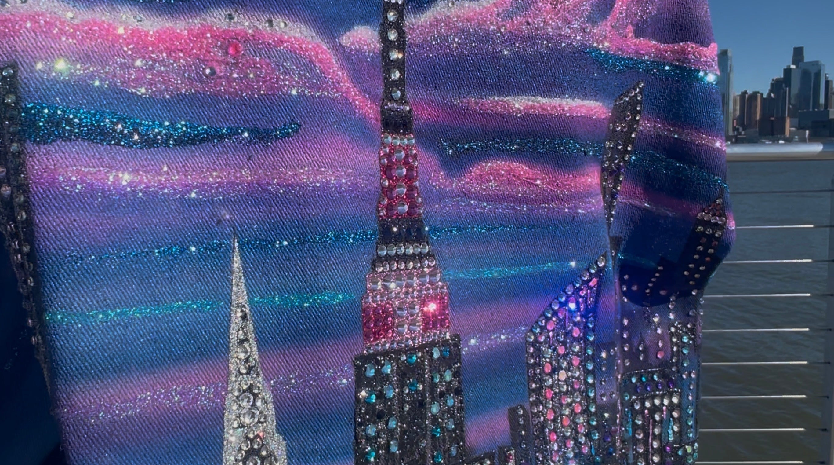 City Loria NYC Art skyline at night with illuminated buildings against a dark sky.