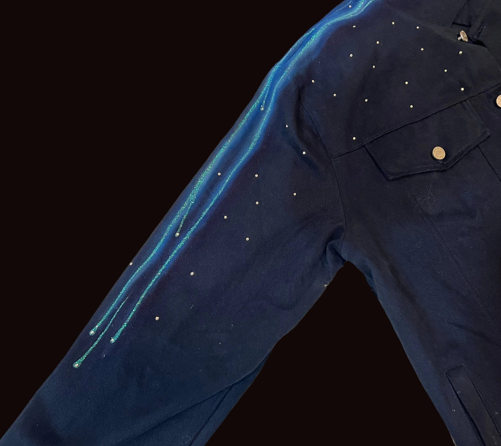 Navy blue Loria NYC Art jacket with gold buttons on a textured beige surface