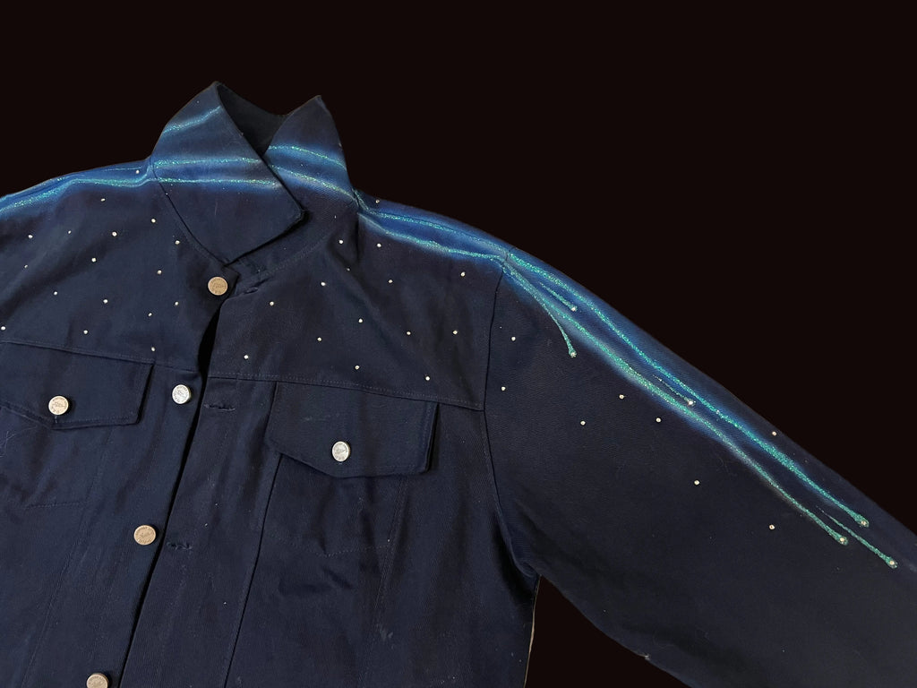 Navy blue jacket with white button details on a beige textured surface