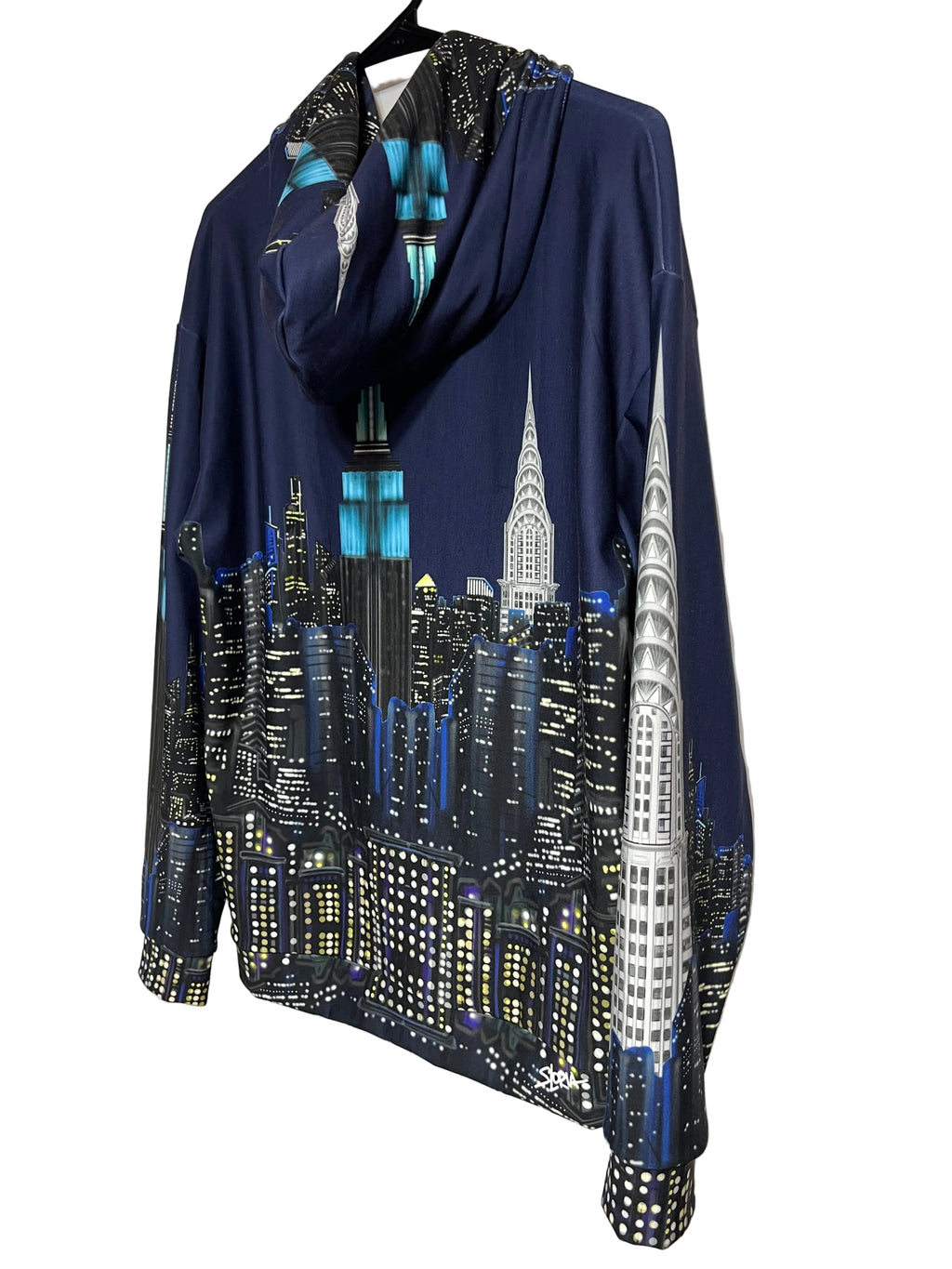 A navy blue long-sleeve top with a black and white New York City skyline Loria NYC Art print, laid flat on a  white background.