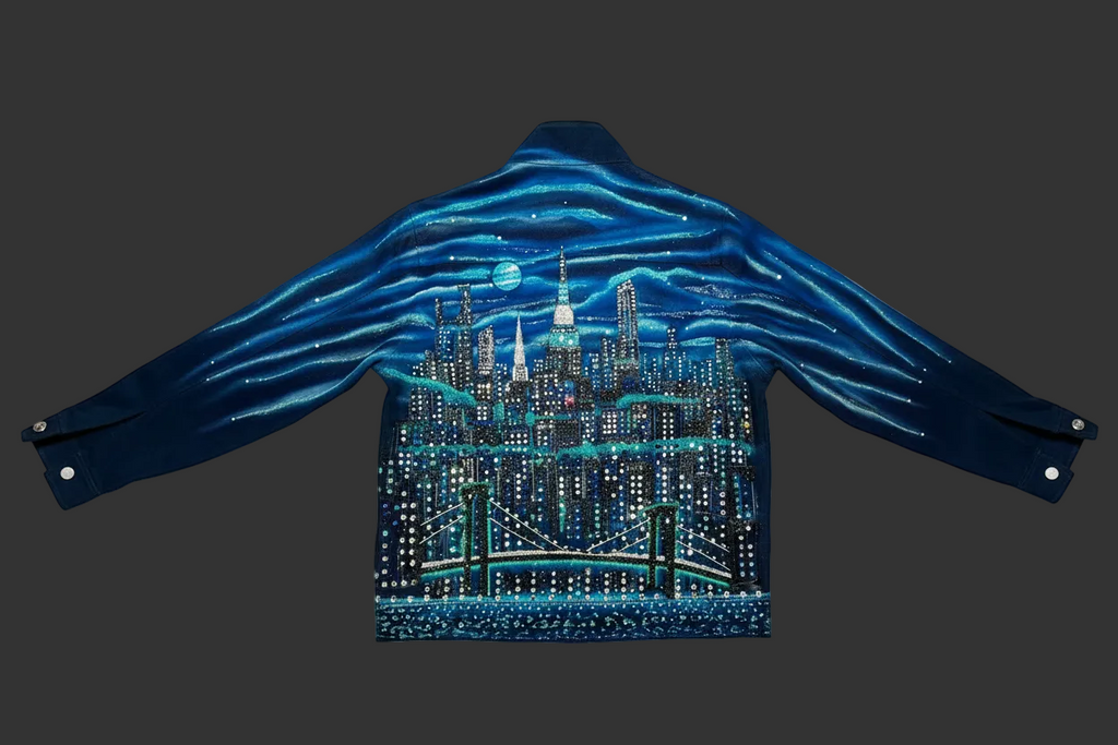 Blue jacket with a Loria NYC Art cityscape design on the back against a white background