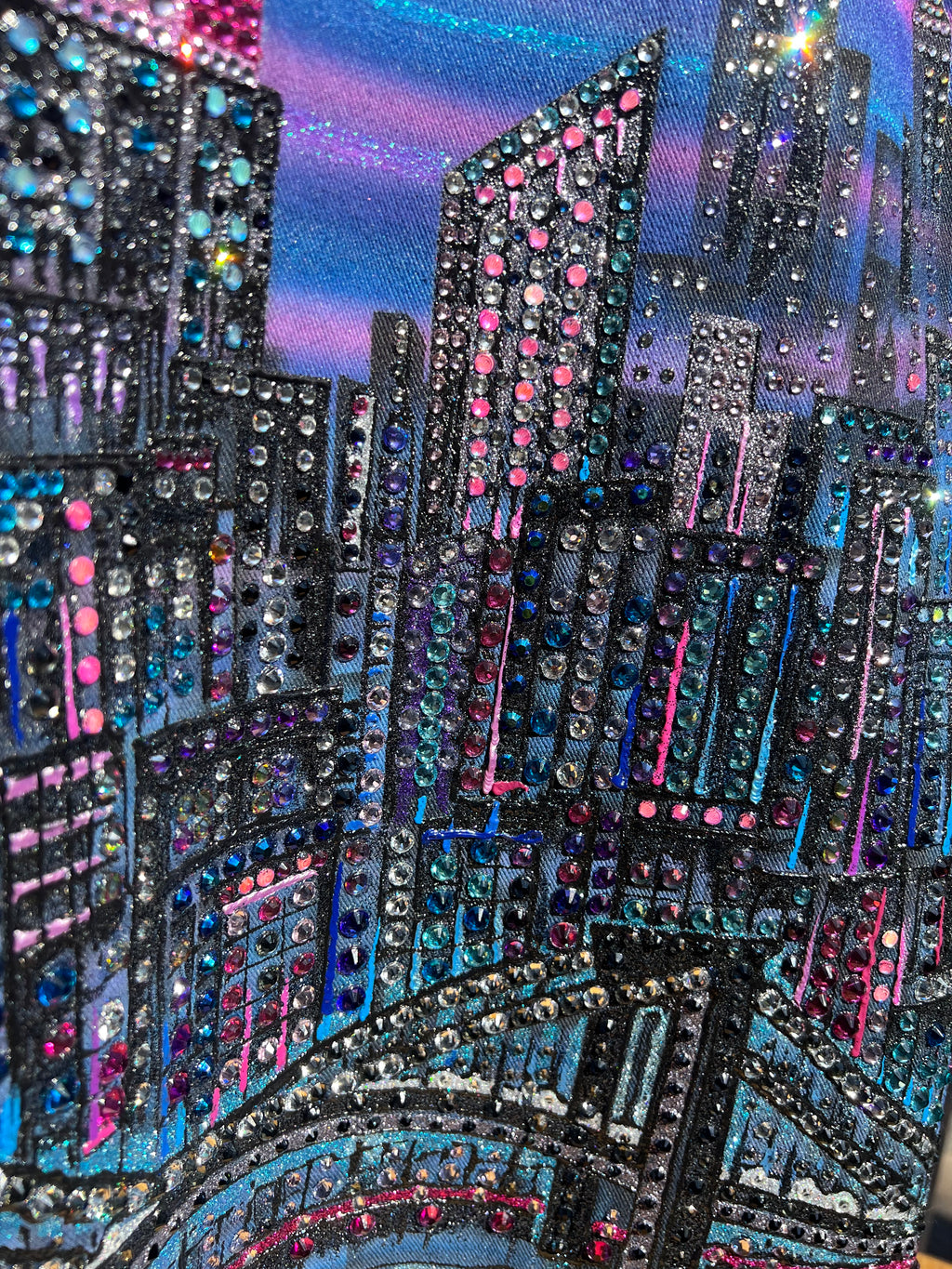 Close-up of a decorative Loria NYC Art fabric with sequins and beads in various colors.