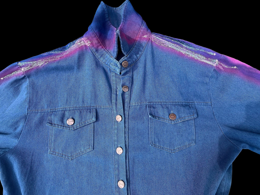 Blue denim shirt with a colorful Loria NYC Art on a textured surface