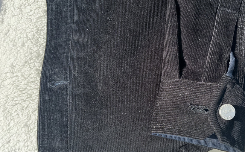 Dark Loria NYC Art denim jacket on a textured surface