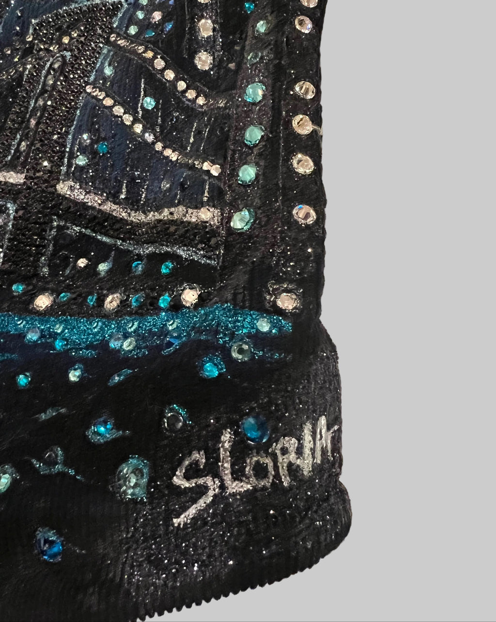 Dark blue sequined Loria NYC Art garment with 'SLoria' branding on a neutral background