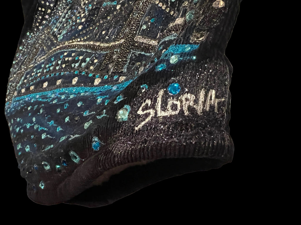 Black beaded Loria NYC Art garment with 'SLoria ' branding on a white surface
