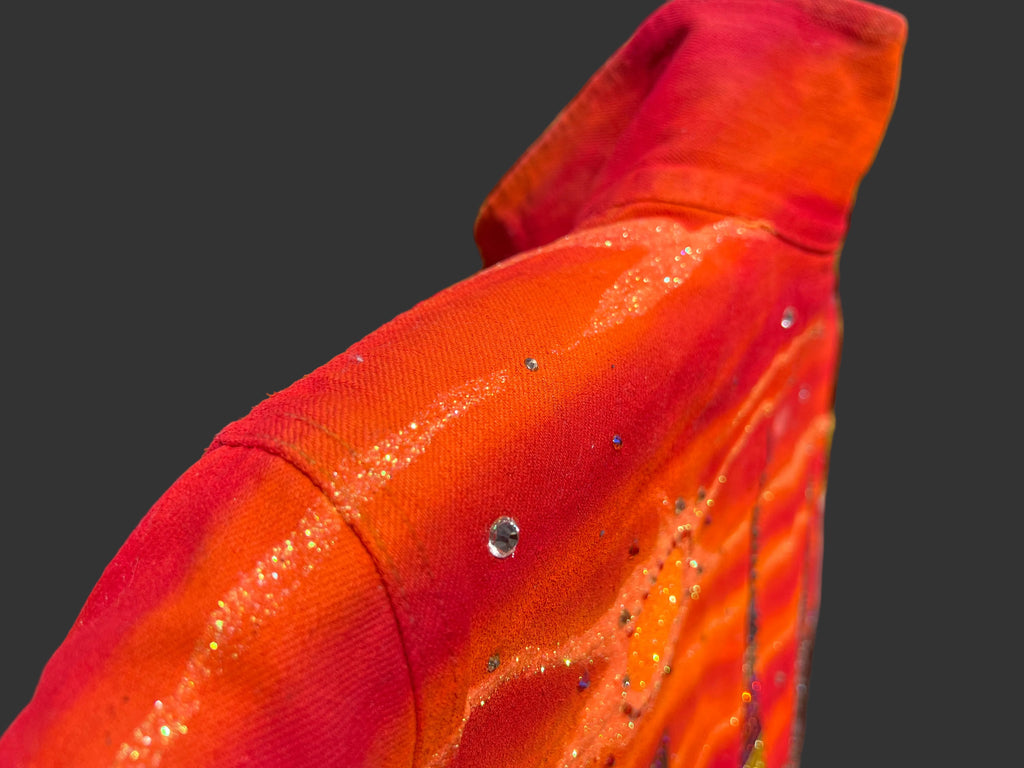 Close-up of a Loria NYC Art jacket with small glass crystals and a grey background.