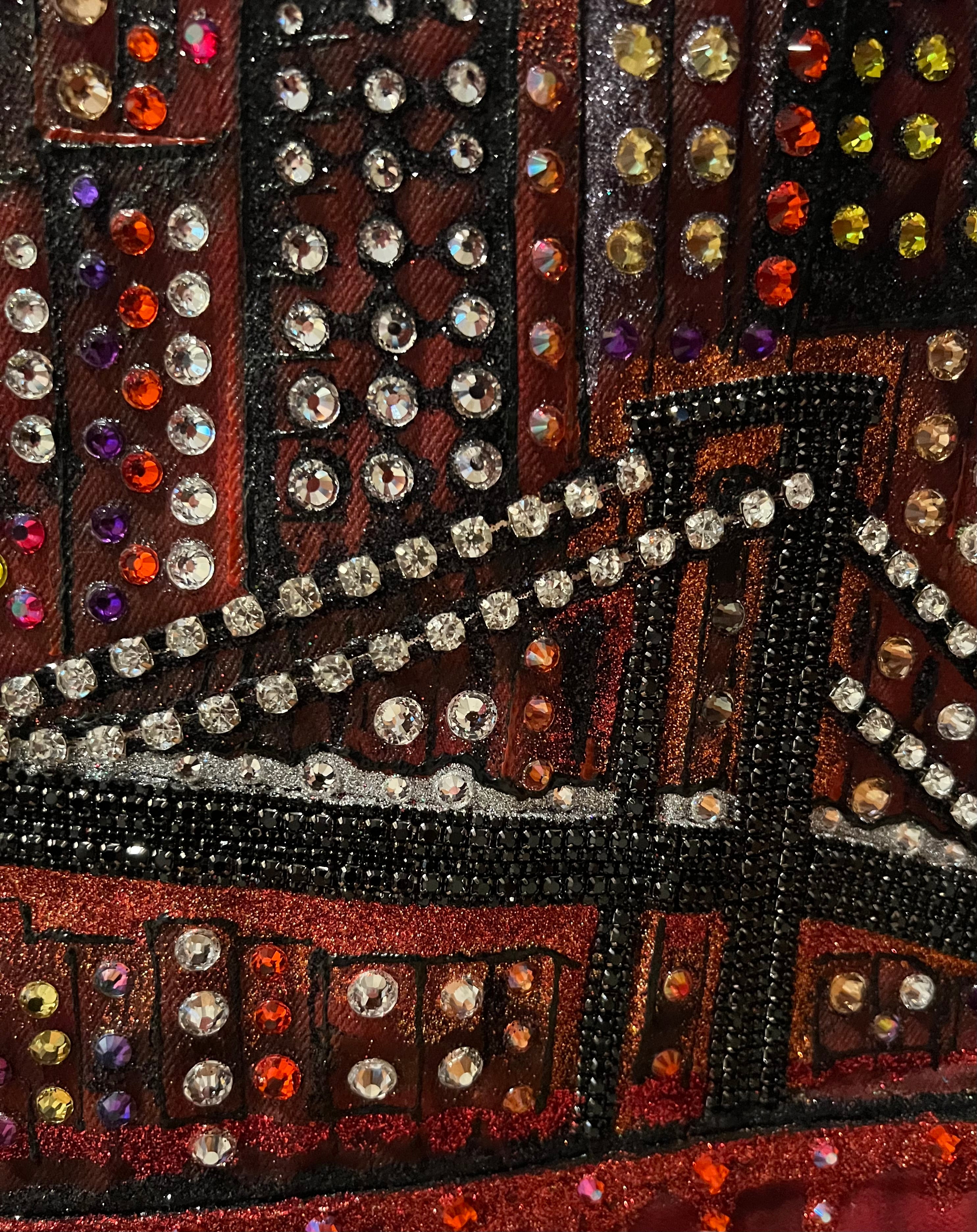 Close-up of a decorative Loria NYC Art item with rhinestones and beads on a brown background