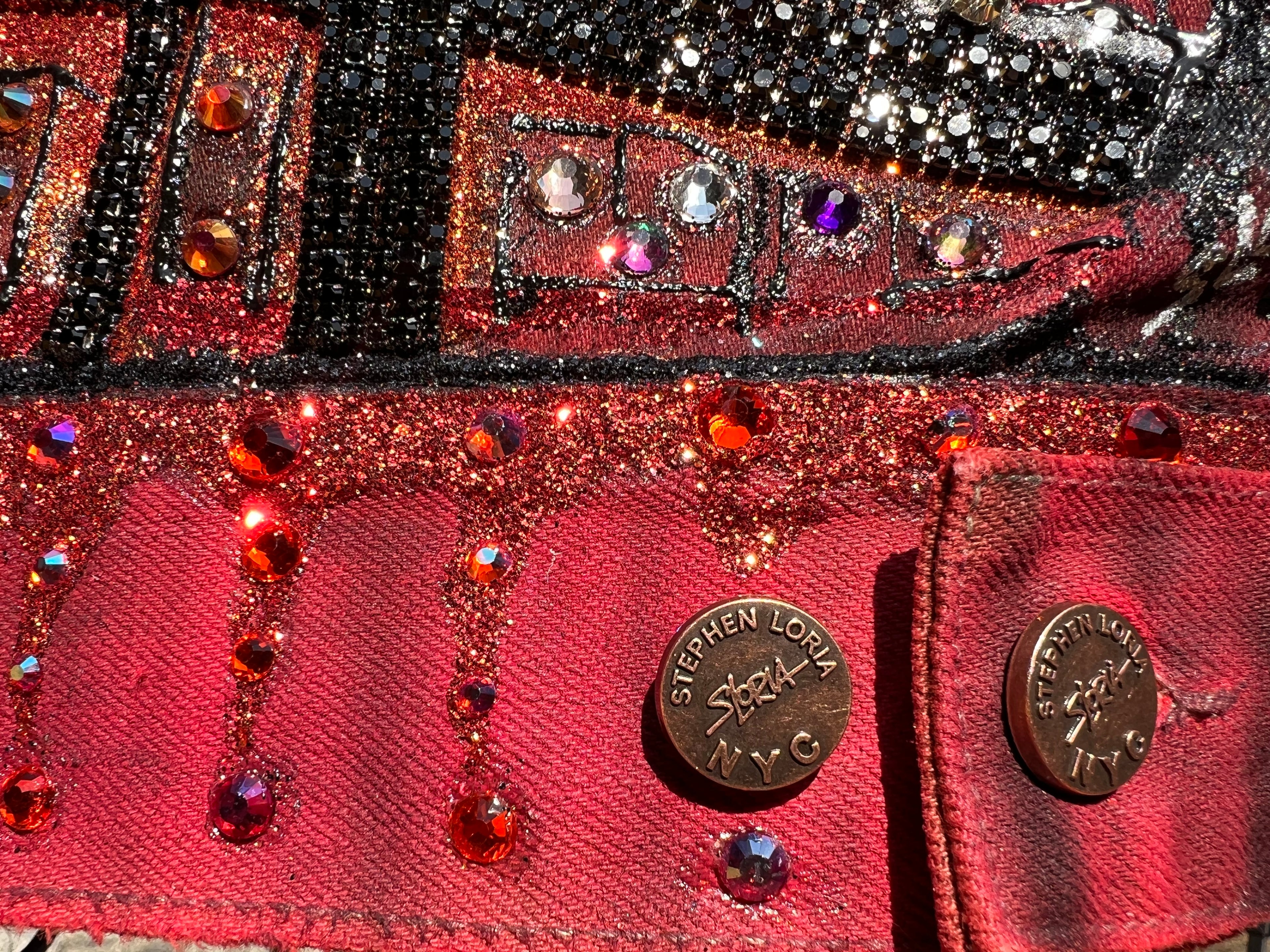 Close-up of a red jacket with embellishments and 'Stephen Loria' branding.