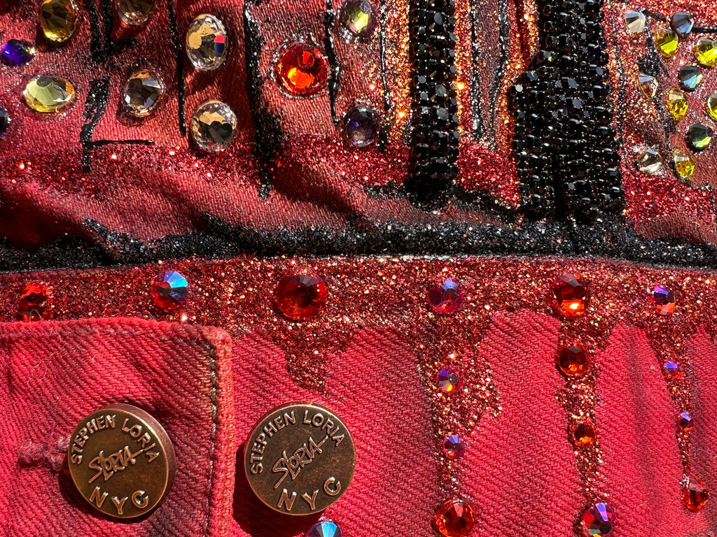 Close-up of a red handbag with decorative elements and 'Stephen Loria' branding.