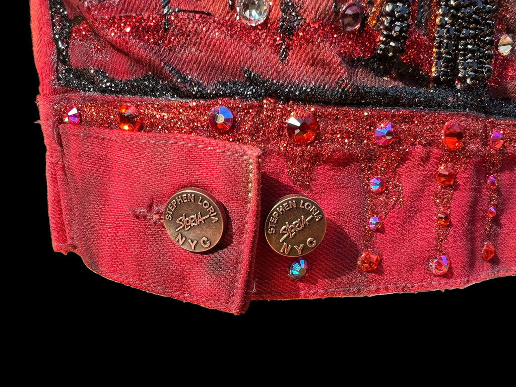 Close-up of a red embellished jacket with 'Stephen Loria' branding on a black background 