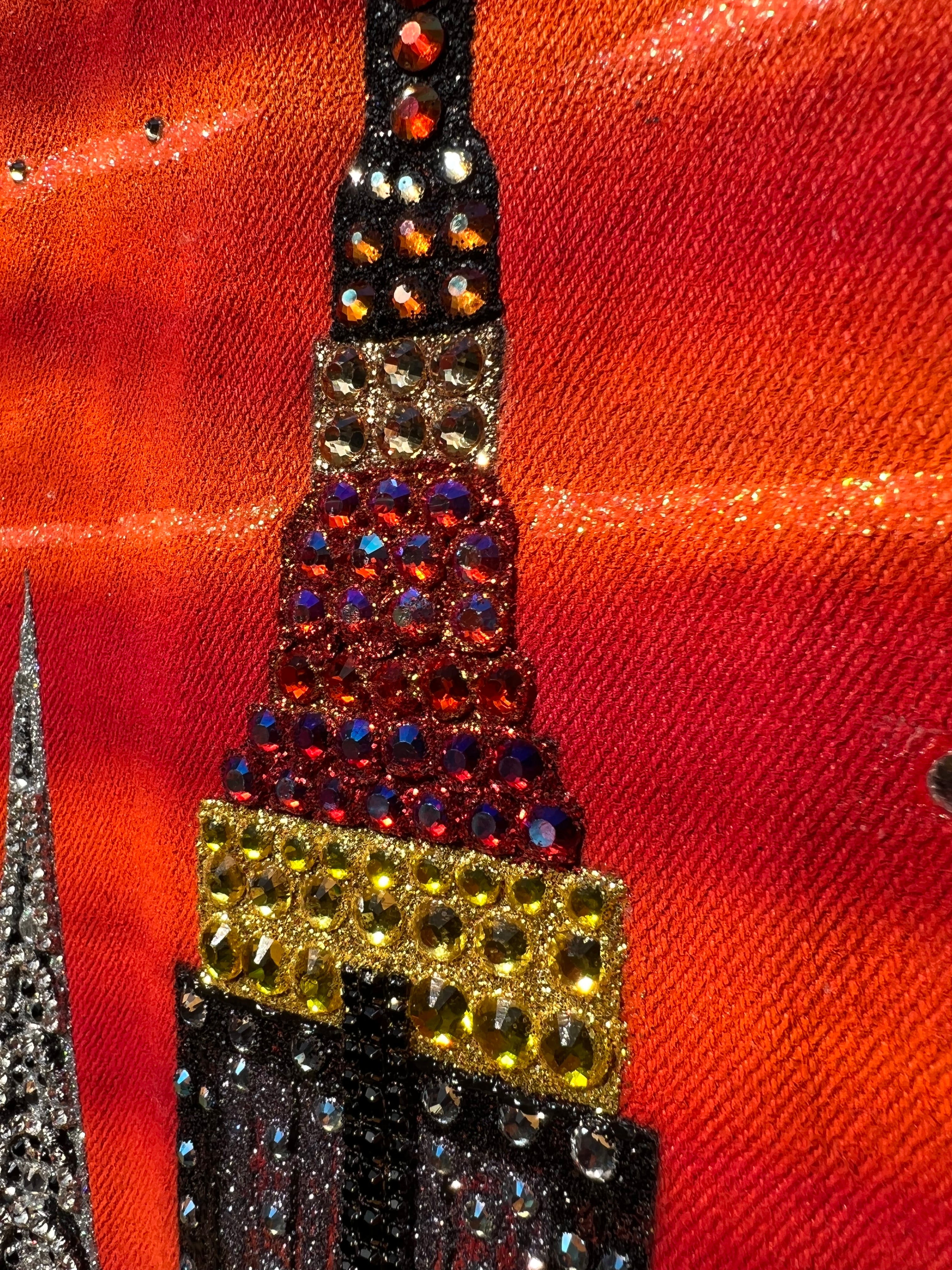 Close-up of a decorative  Loria NYC Art with multicolored stones on a red fabric background
