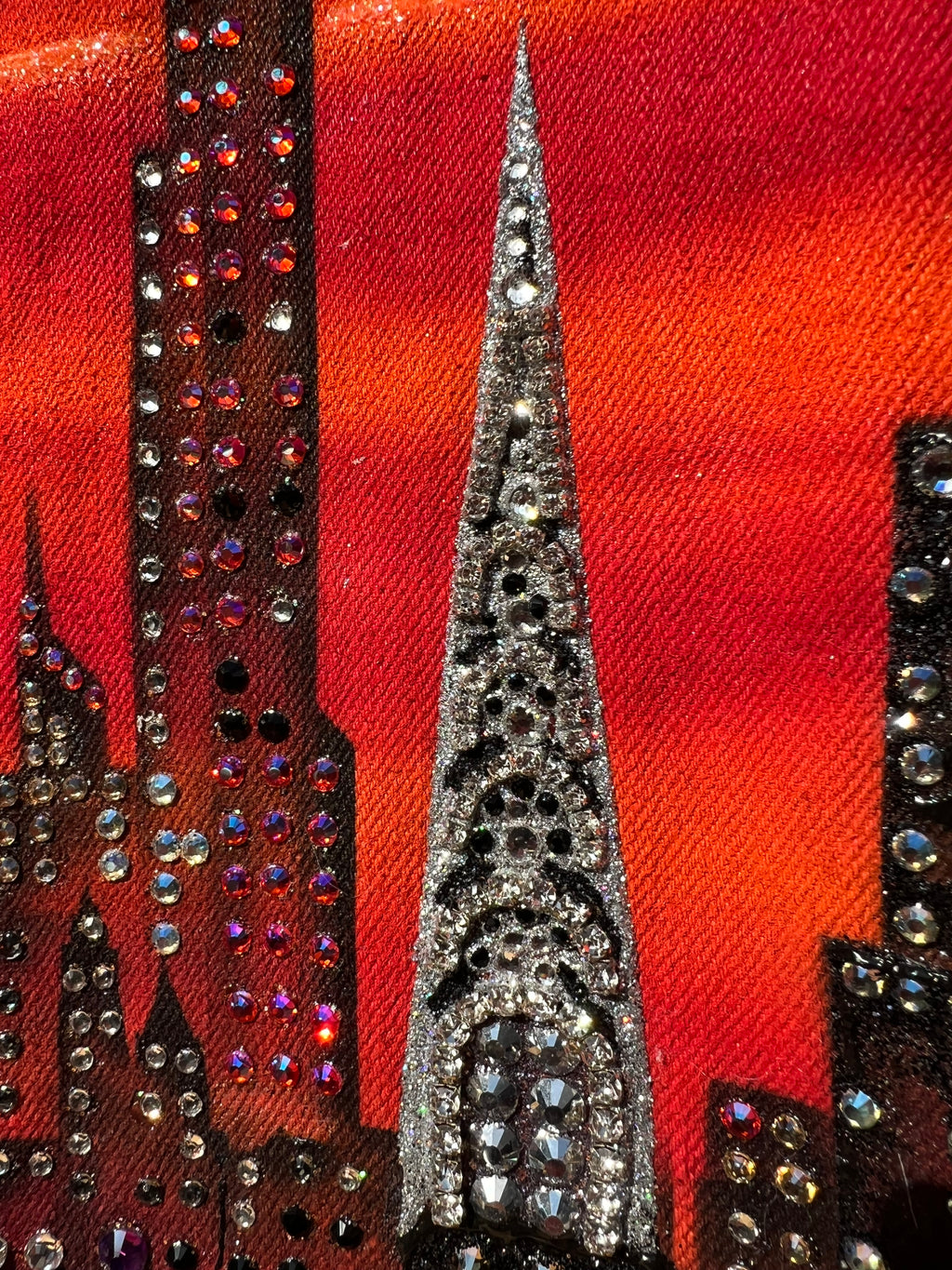 Close-up of  Loria NYC Art decorative fabric with rhinestones on a red background