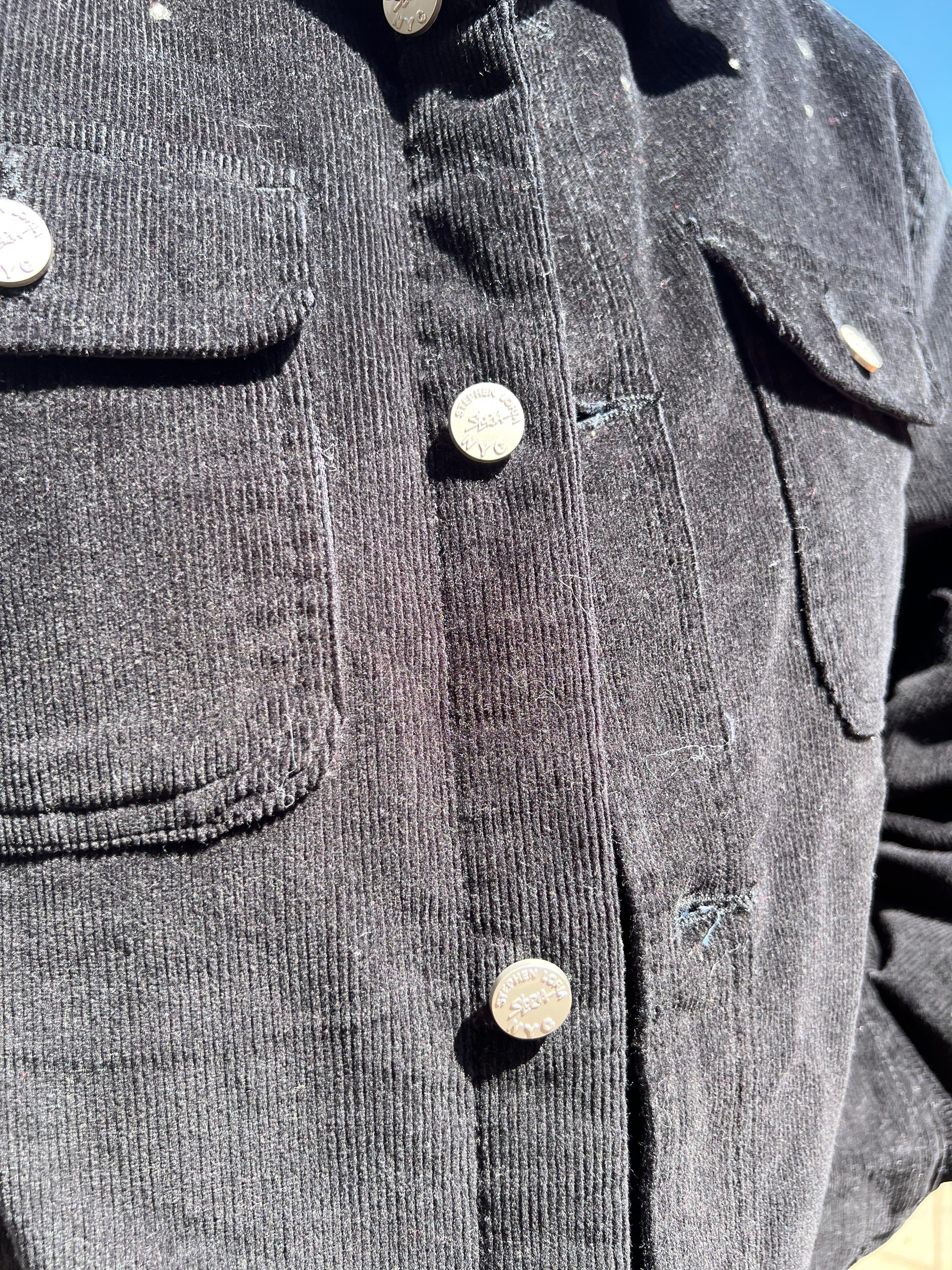 Close-up of a gray Loria NYC Art corduroy jacket with buttons and pockets.
