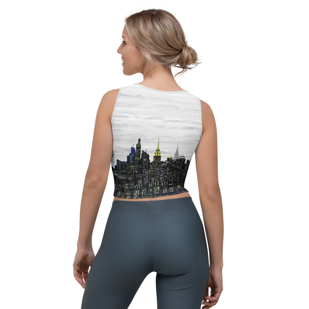 Woman wearing a sleeveless crop top with a Loria NYC Art cityscape design on a white background