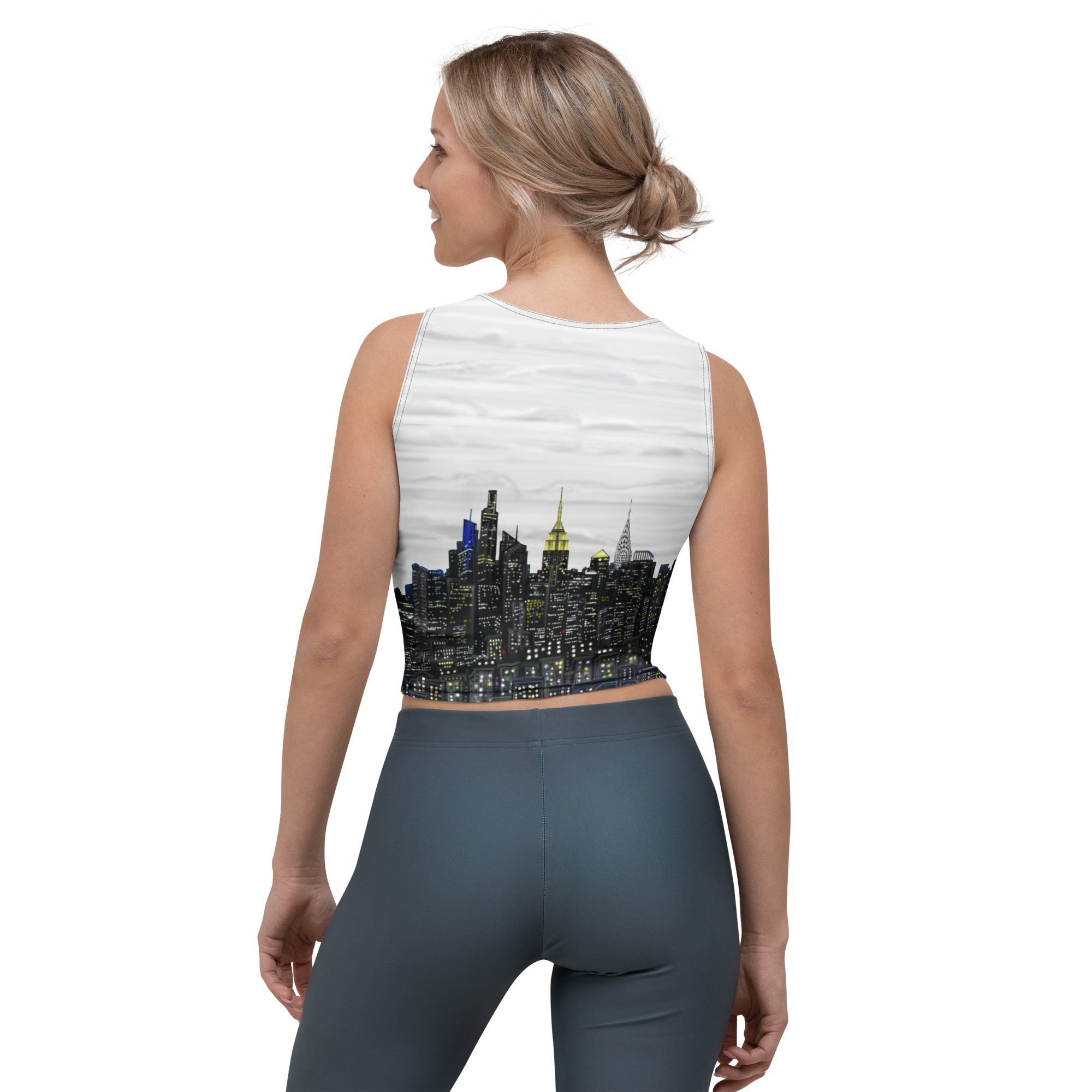 Woman wearing a sleeveless crop top with a Loria NYC Art cityscape design on a white background