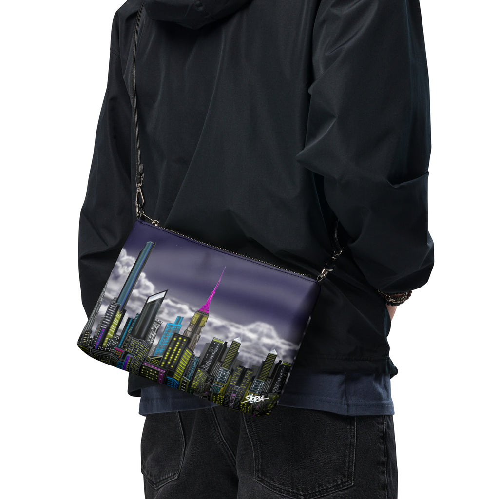 Person wearing a black jacket with a cityscape bag featuring a pink tower.