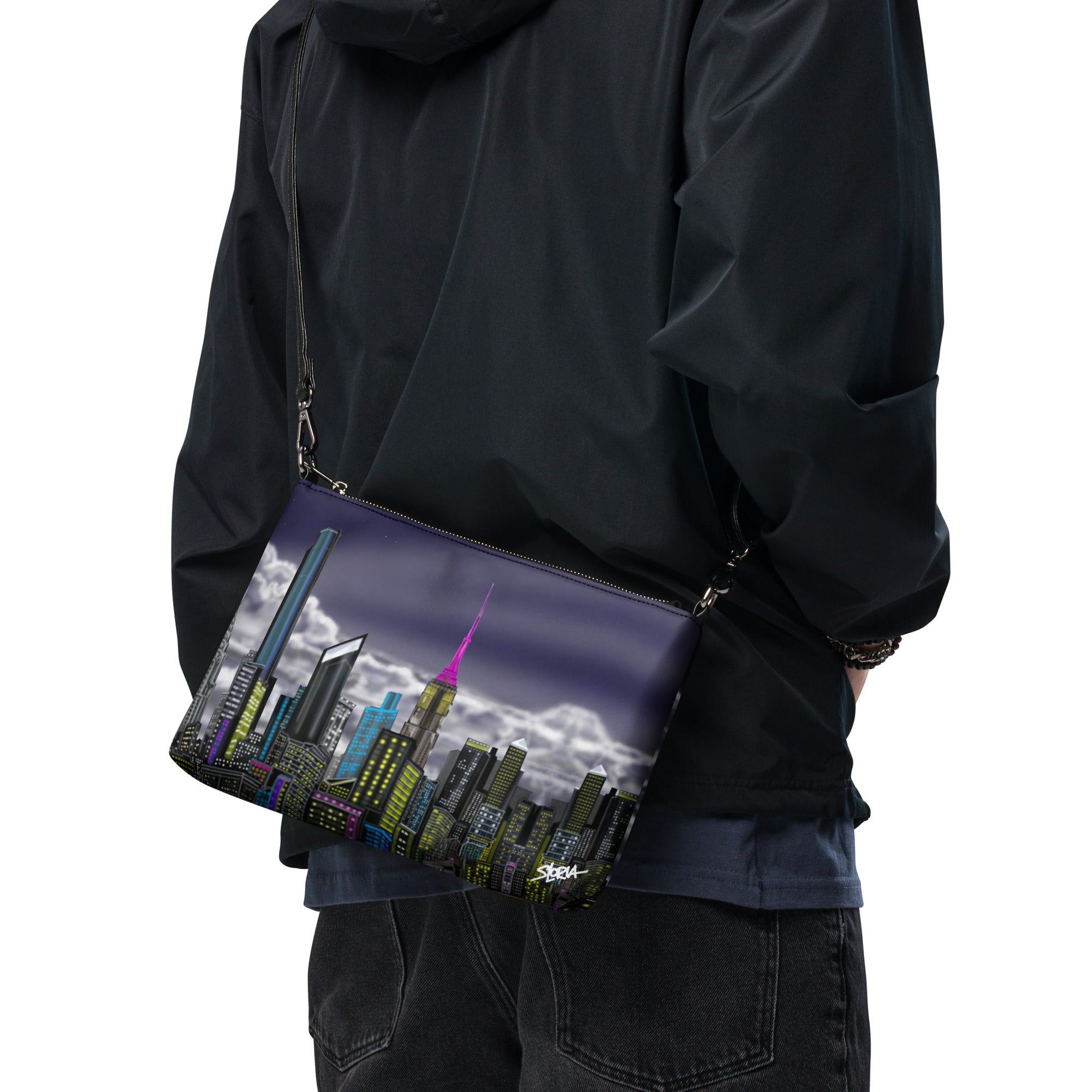 Person wearing a black jacket with a cityscape bag featuring a pink tower.