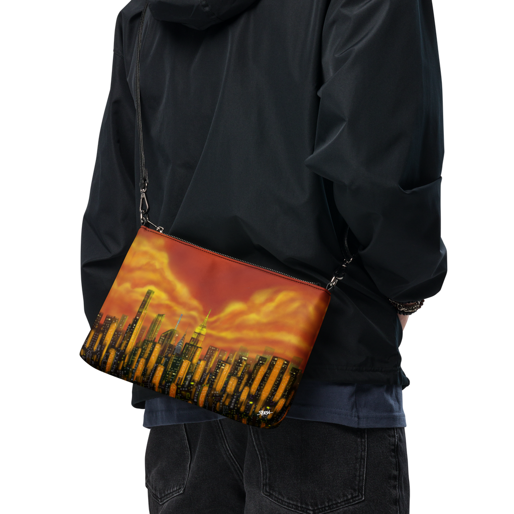 Person wearing a black jacket with a Loria NYC Art crossbody bag featuring a cityscape design.