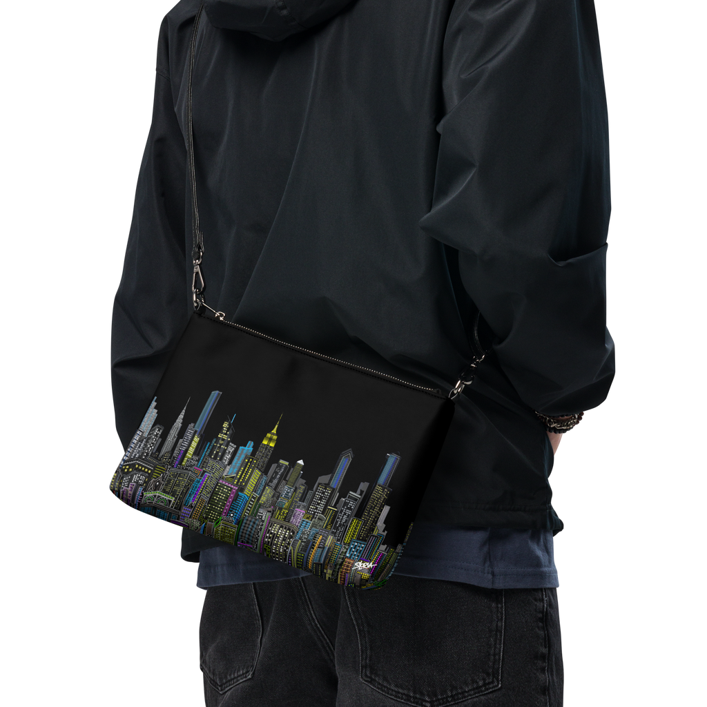 Person wearing a black jacket with a colorful Loria NYC Art cityscape bag on a transparent background