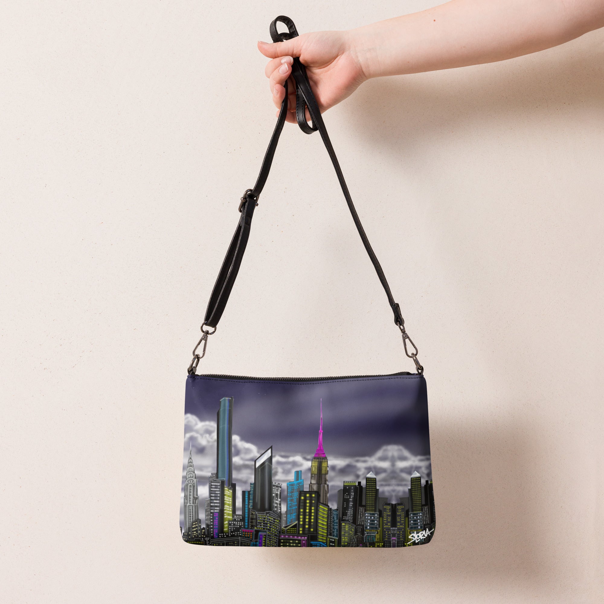 Handbag with cityscape Loria NYC art design held by a hand against a beige back ground