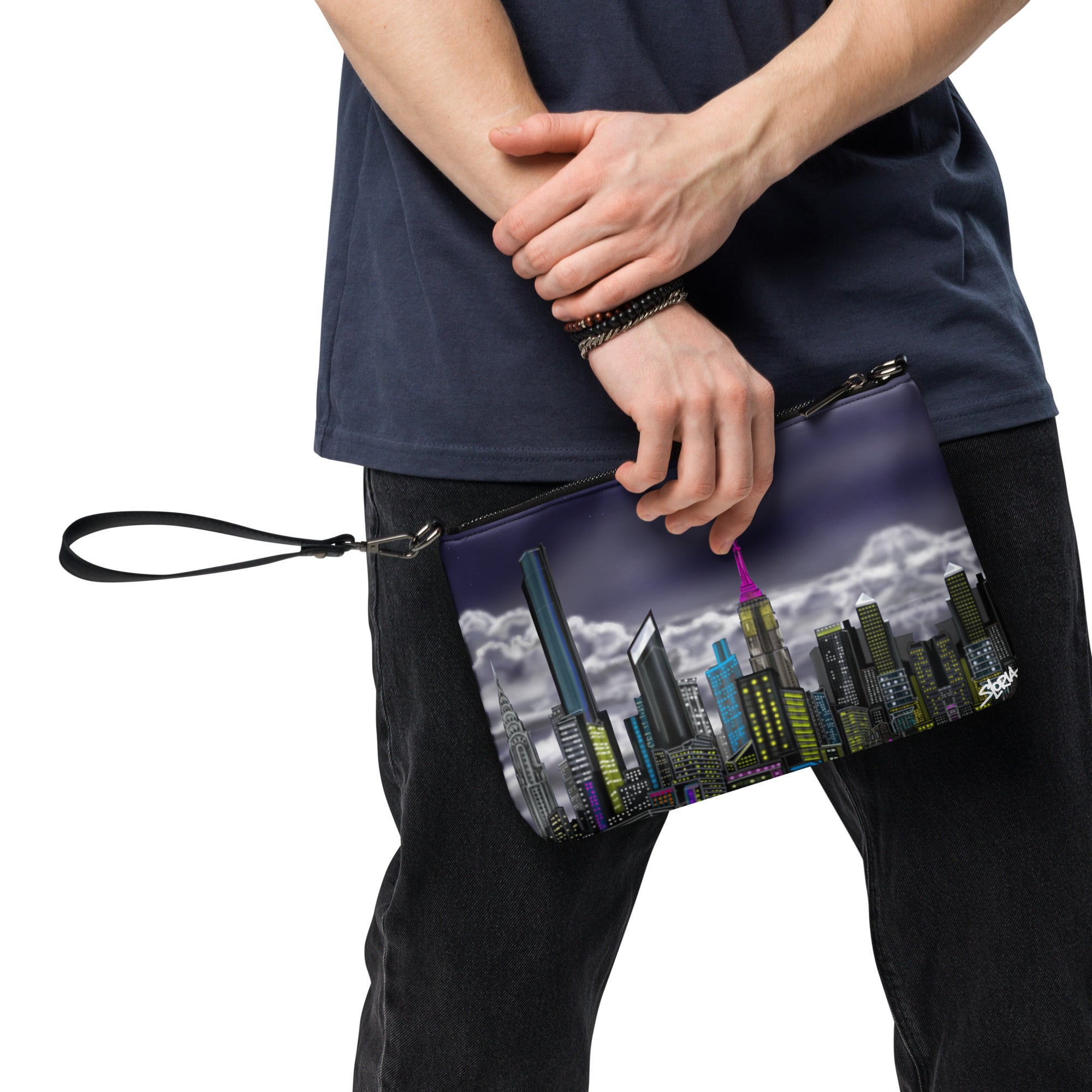Person holding a clutch with cityscape design on a white background