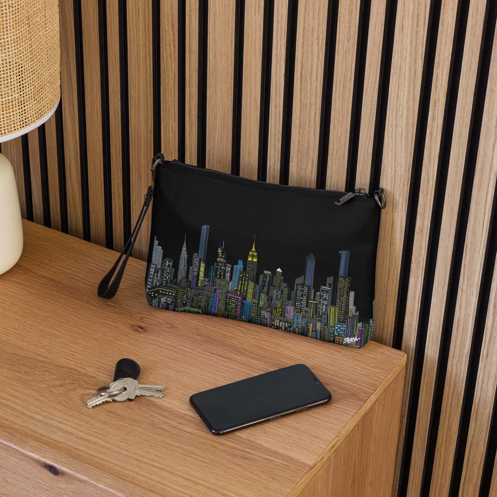 Black pouch with cityscape Loria NYC Art design on a wooden surface with keys and phone.