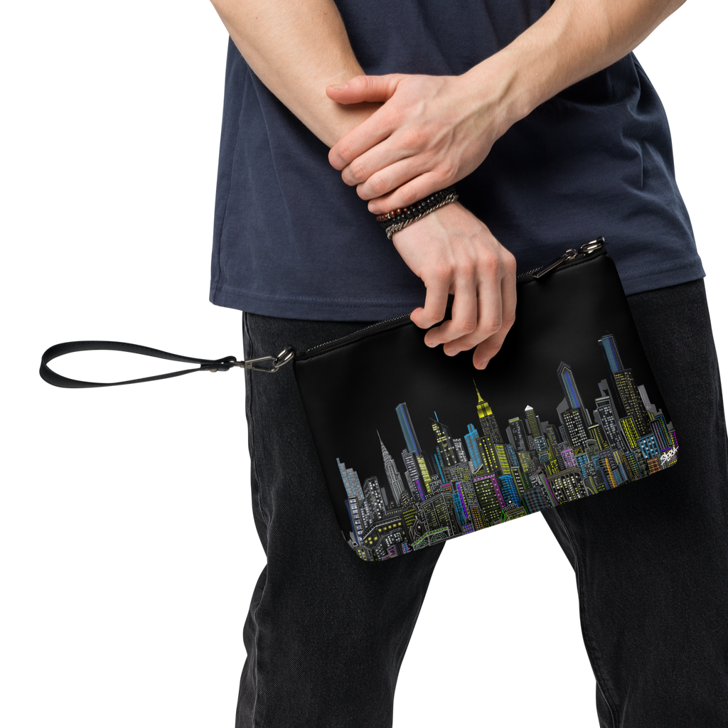Person holding a Loria NYC Art black clutch with cityscape design