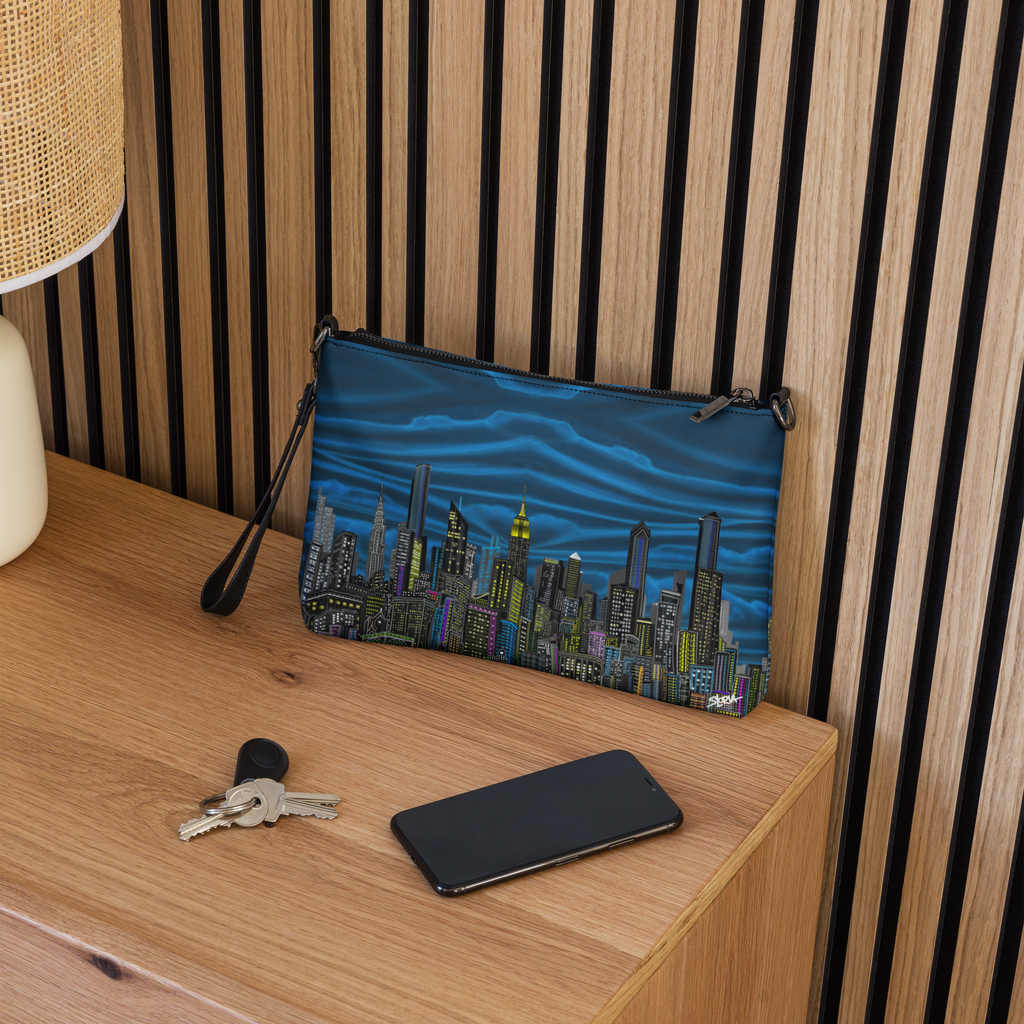 Blue pouch with cityscape Loria NYC Art design on a wooden surface with keys and phone.