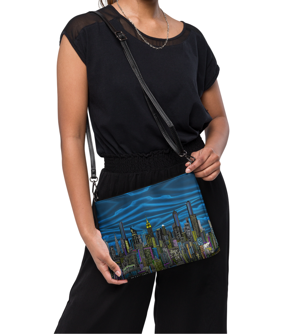 Woman holding a Loria NYC Art blue bag with a cityscape design on a white background