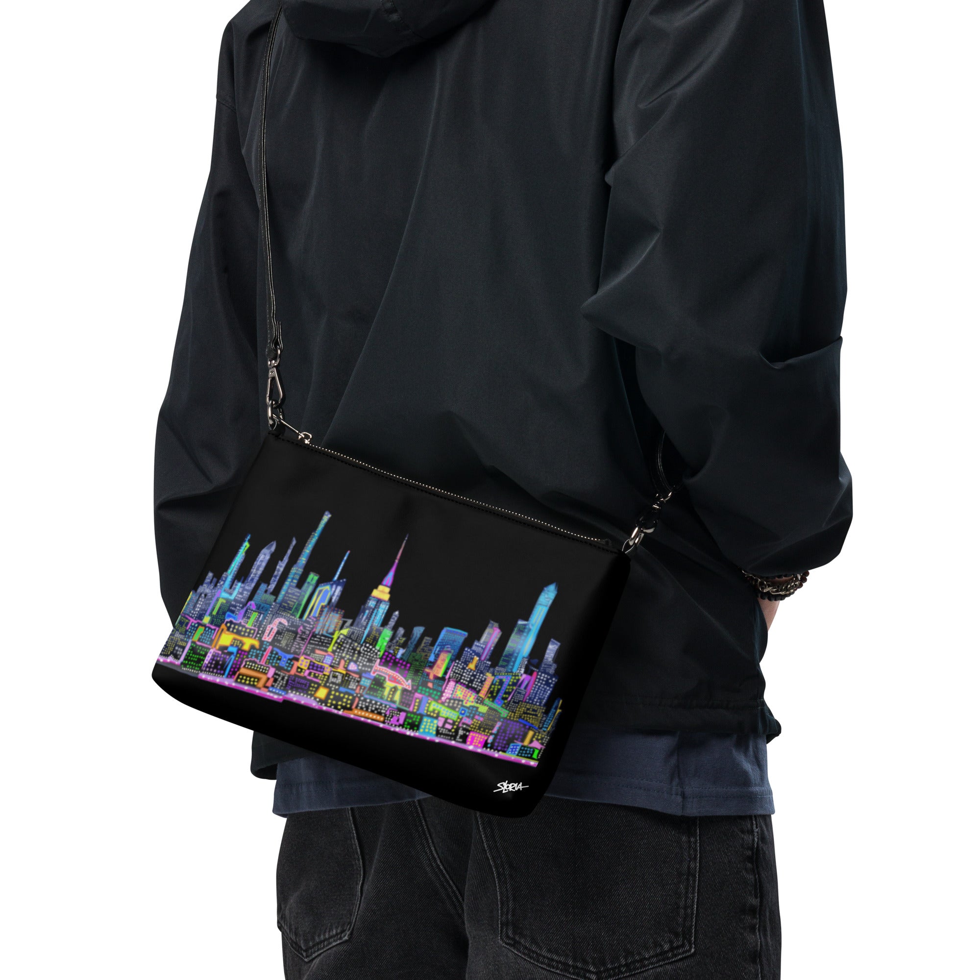Person wearing a black jacket with a colorful cityscape bag on a white background