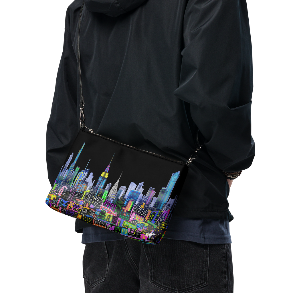 Person wearing a black jacket with a Loria NYC Art colorful cityscape bag