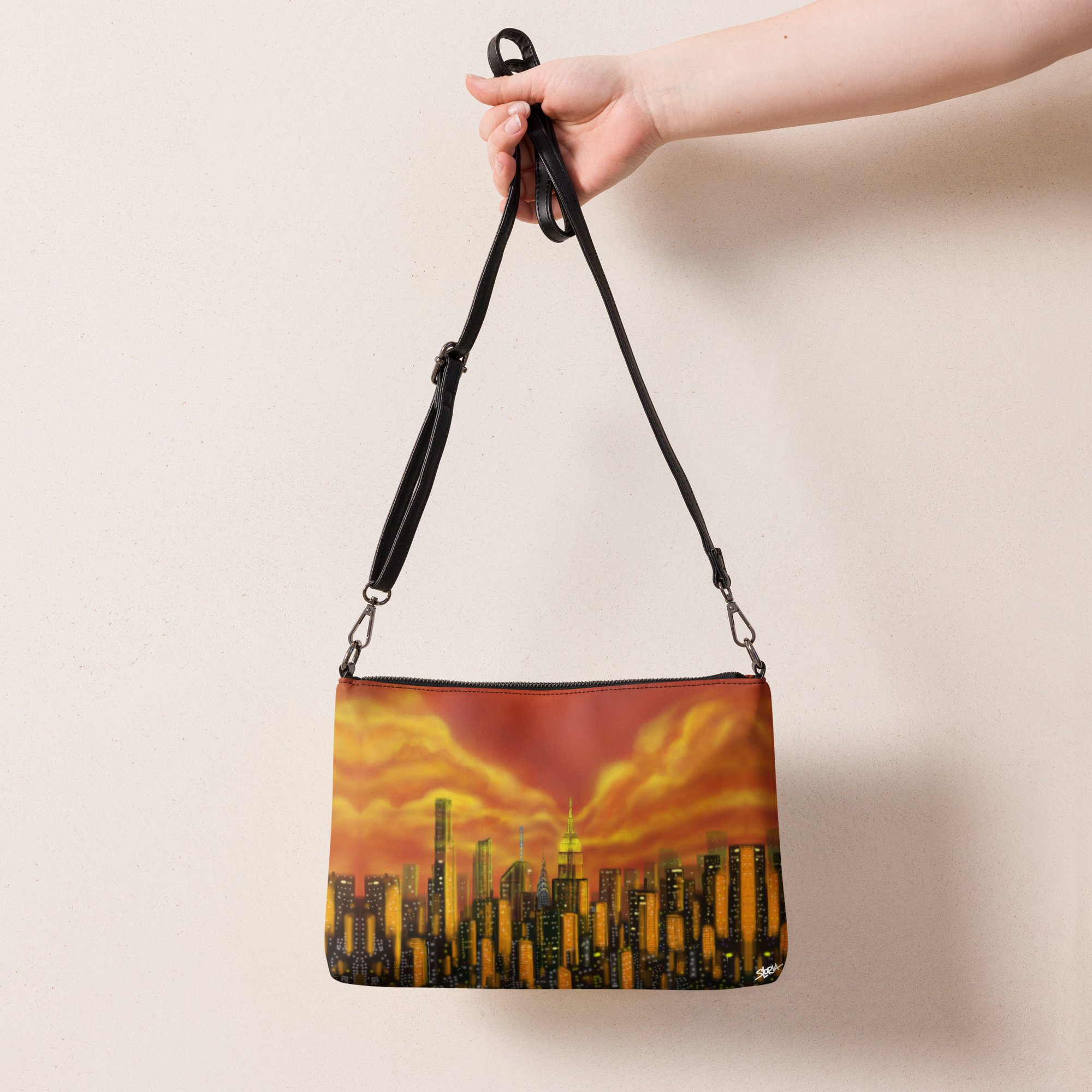 Handbag with cityscape Loria NYC Art. design held by a hand against a plain background