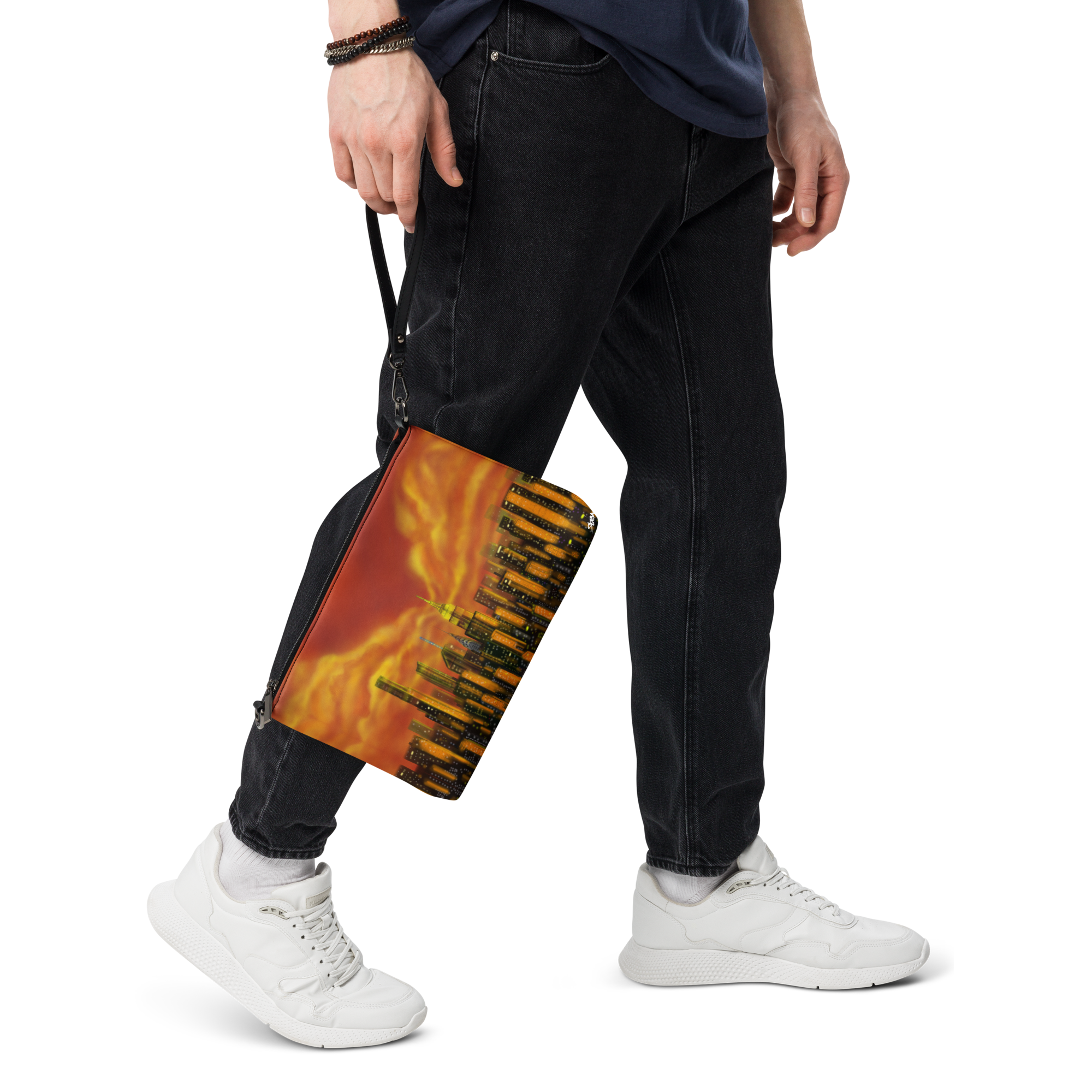 Person wearing black pants and white sneakers holding a Loria NYC Art colorful skateboard with a flame design.
