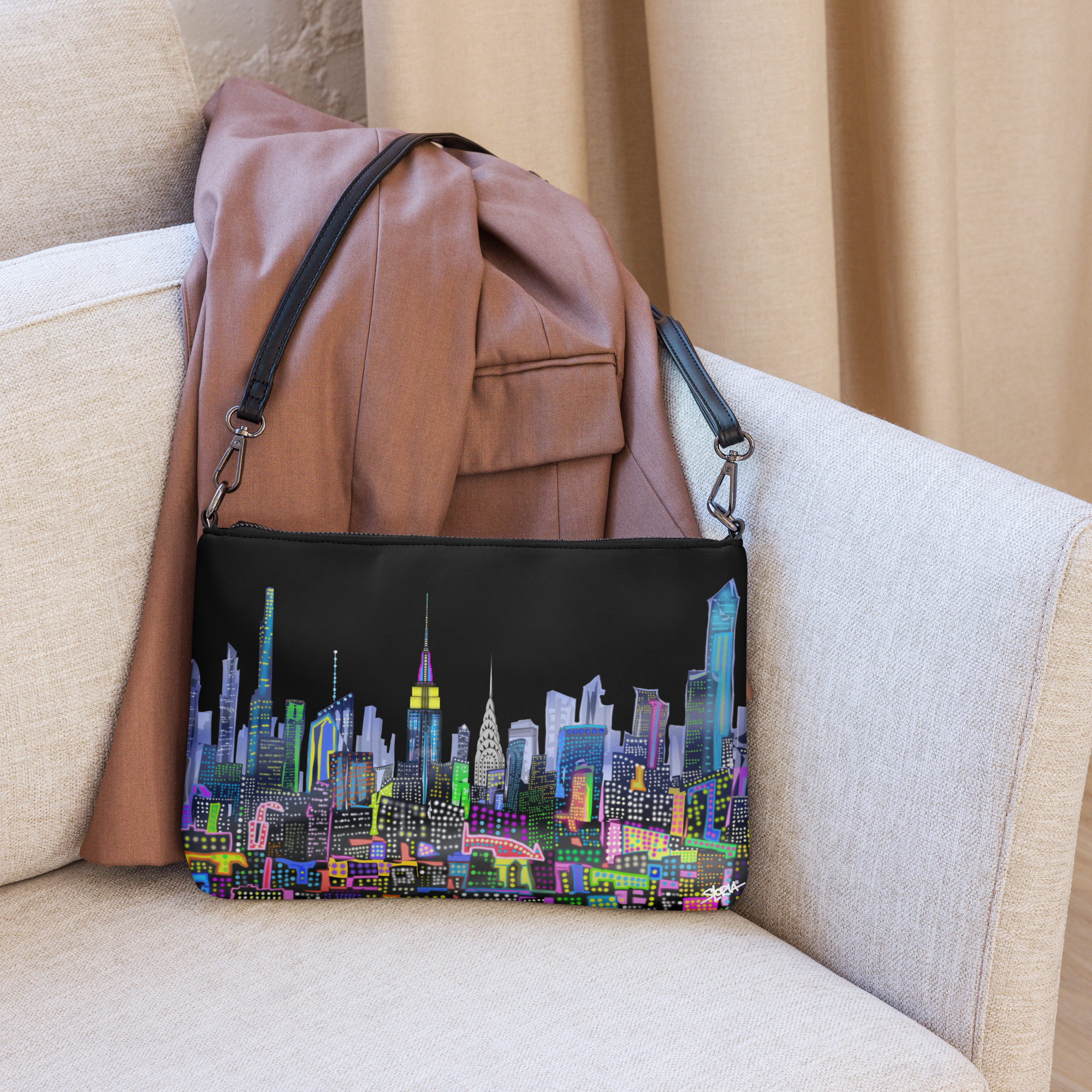 Pocket book with a colorful Loria NYC Art cityscape design on a beige couch