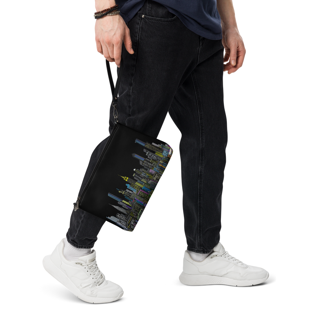Person wearing black pants and white sneakers holding a black Loria NYC Art bag with colorful patterns.