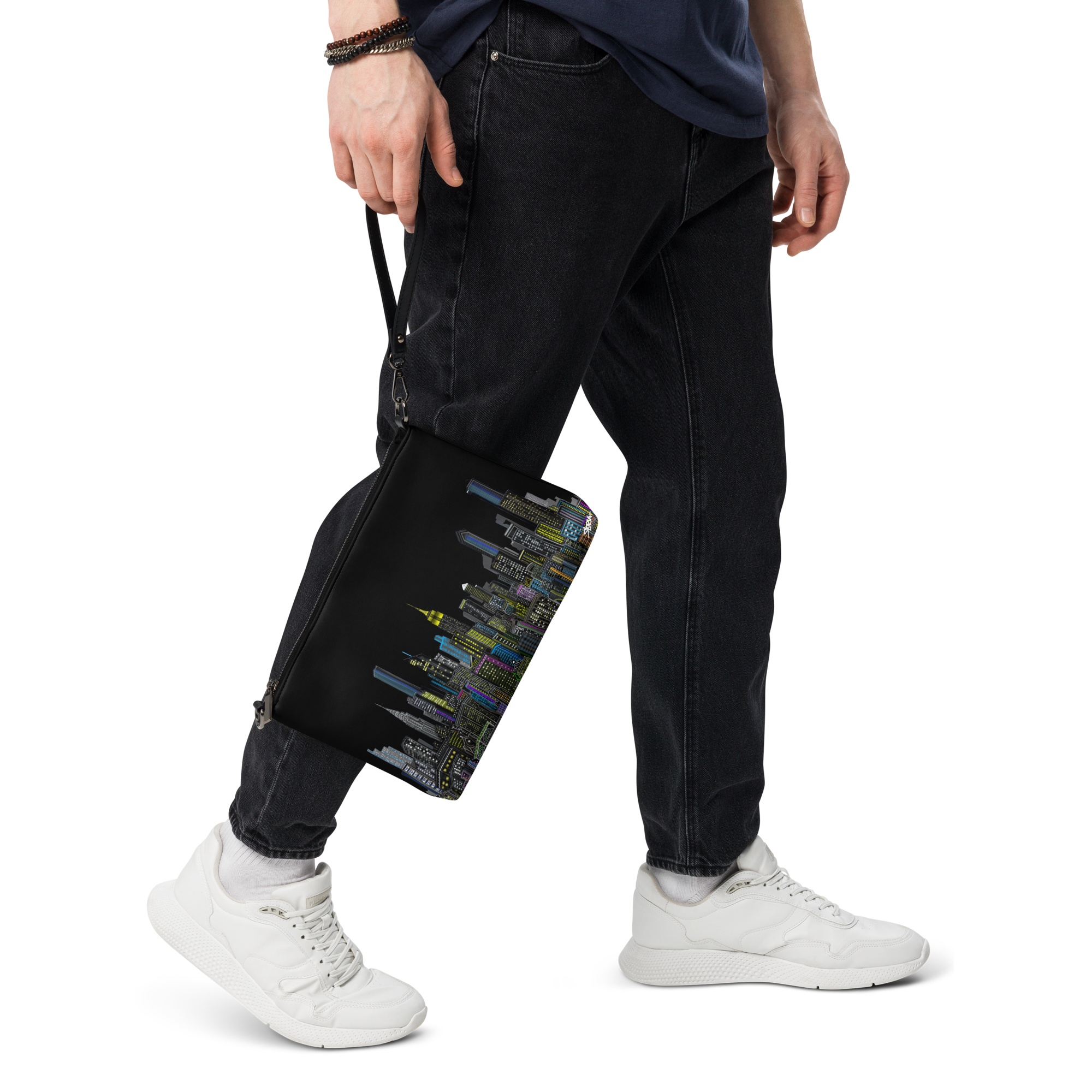 Person wearing black pants and white sneakers holding a black Loria NYC Art bag with colorful patterns.