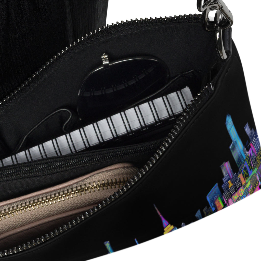 Close-up of a black handbag with a cityscape pattern on a white background