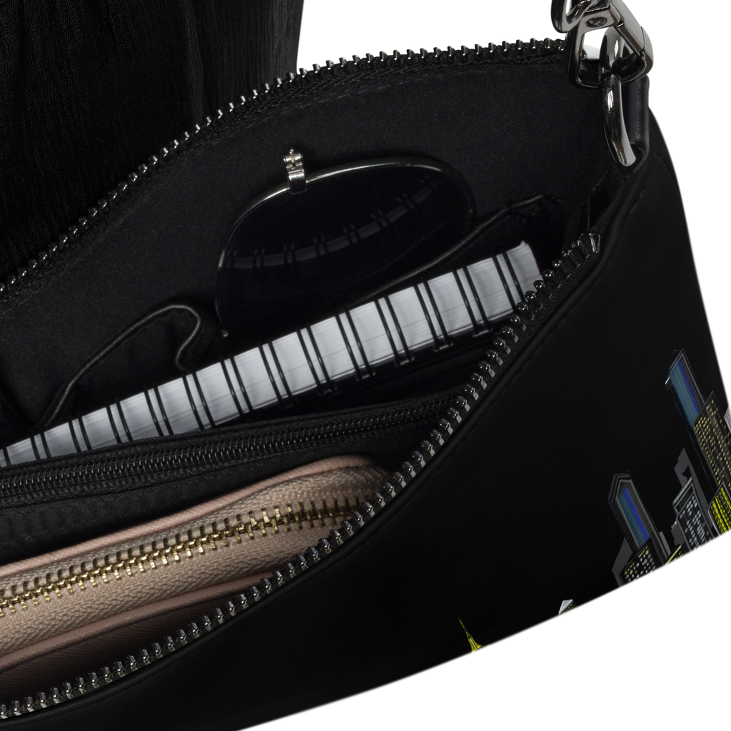 Black Loria NYC Art handbag with gold zipper partially open on a white background