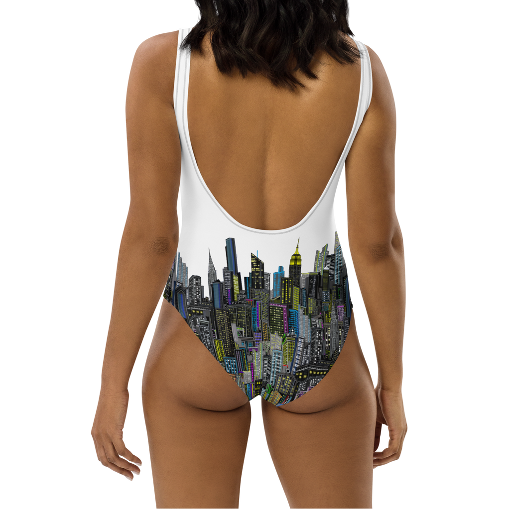 Woman wearing a Loria NYC Art swimsuit with a cityscape design on a white background