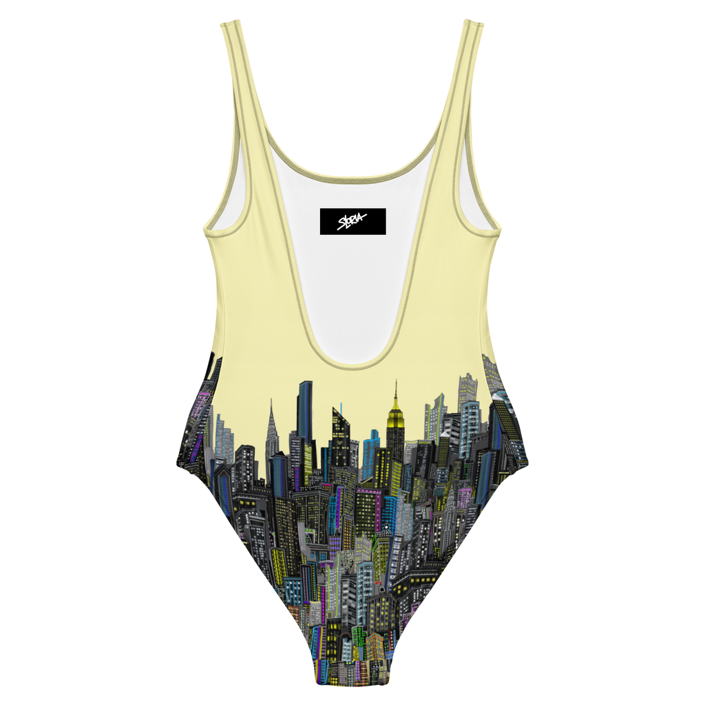 Rear view of a Loria NYC Art One-piece swimsuit with cityscape design on a white background