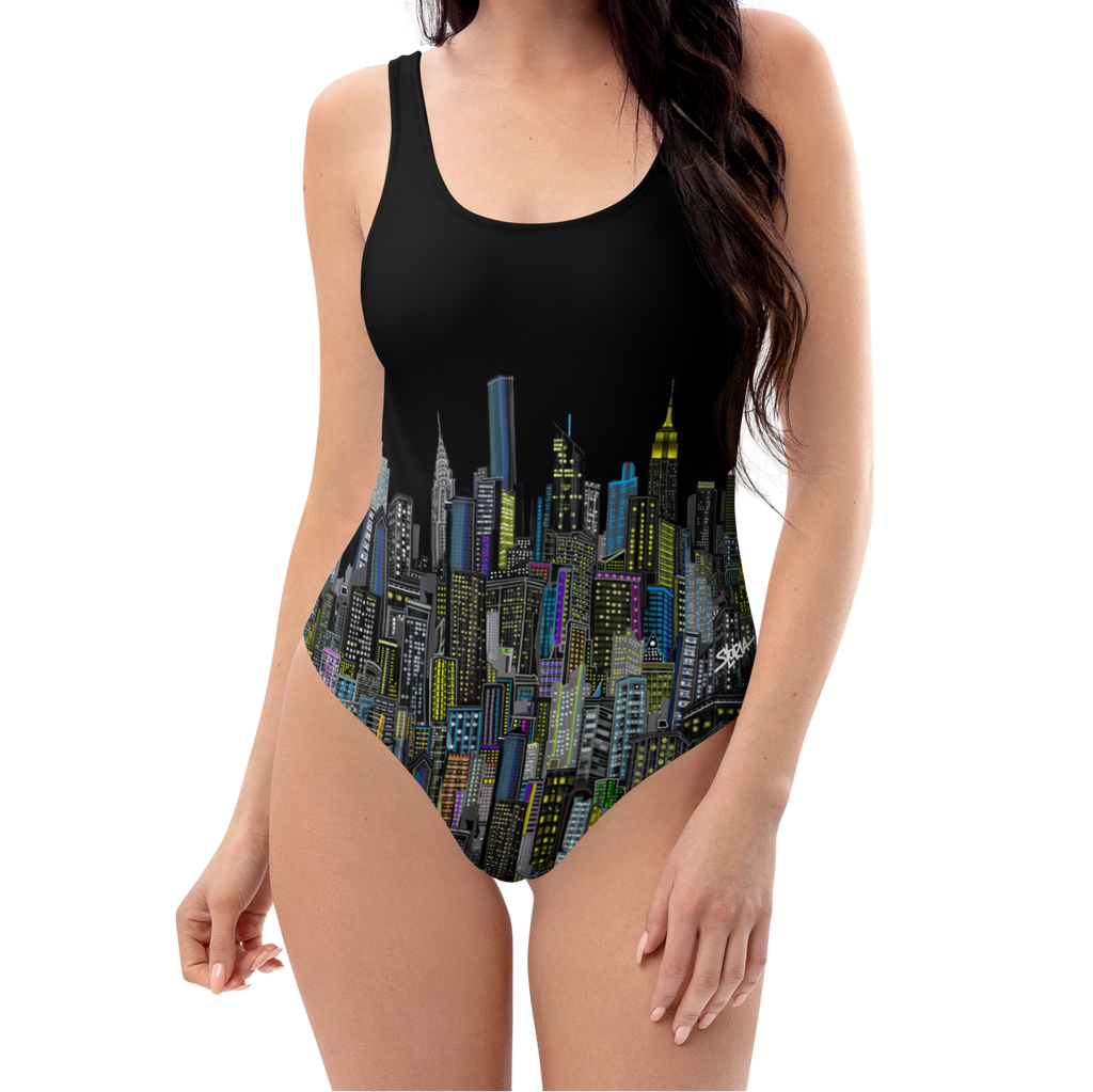 Woman wearing a black one-piece swimsuit with Loria NYC Art cityscape design on a white background