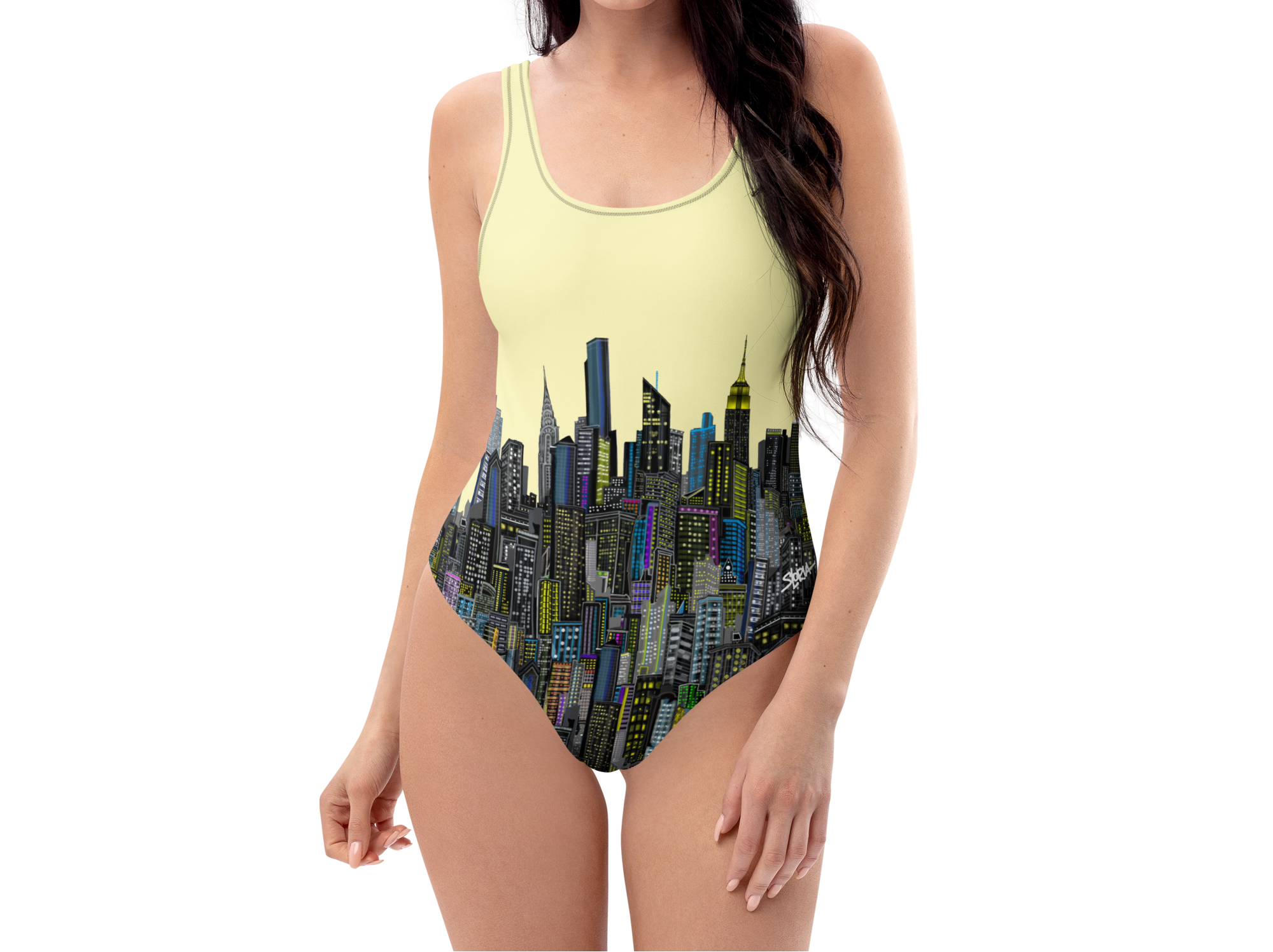 Woman wearing a one-piece Loria NYC Art swimsuit with cityscape design on a white background