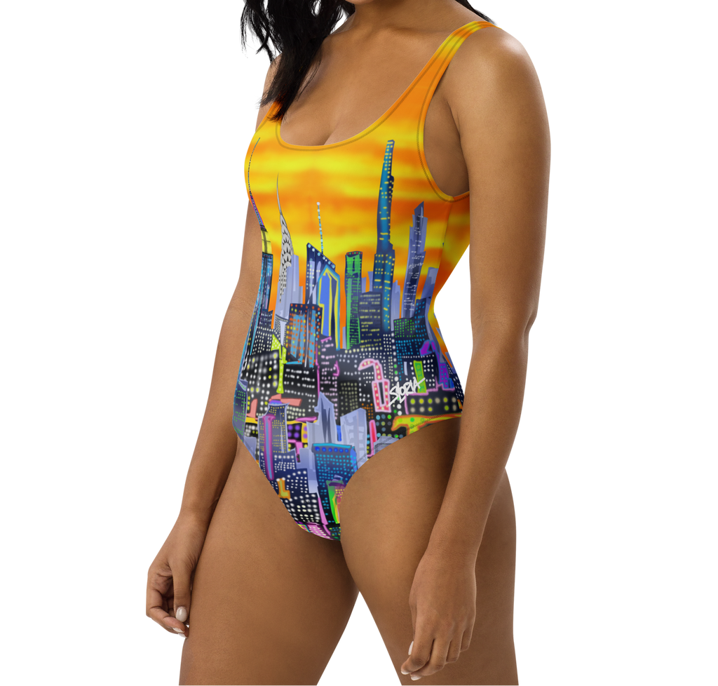Woman wearing a colorful Loria NYC Art cityscape swimsuit on a white background