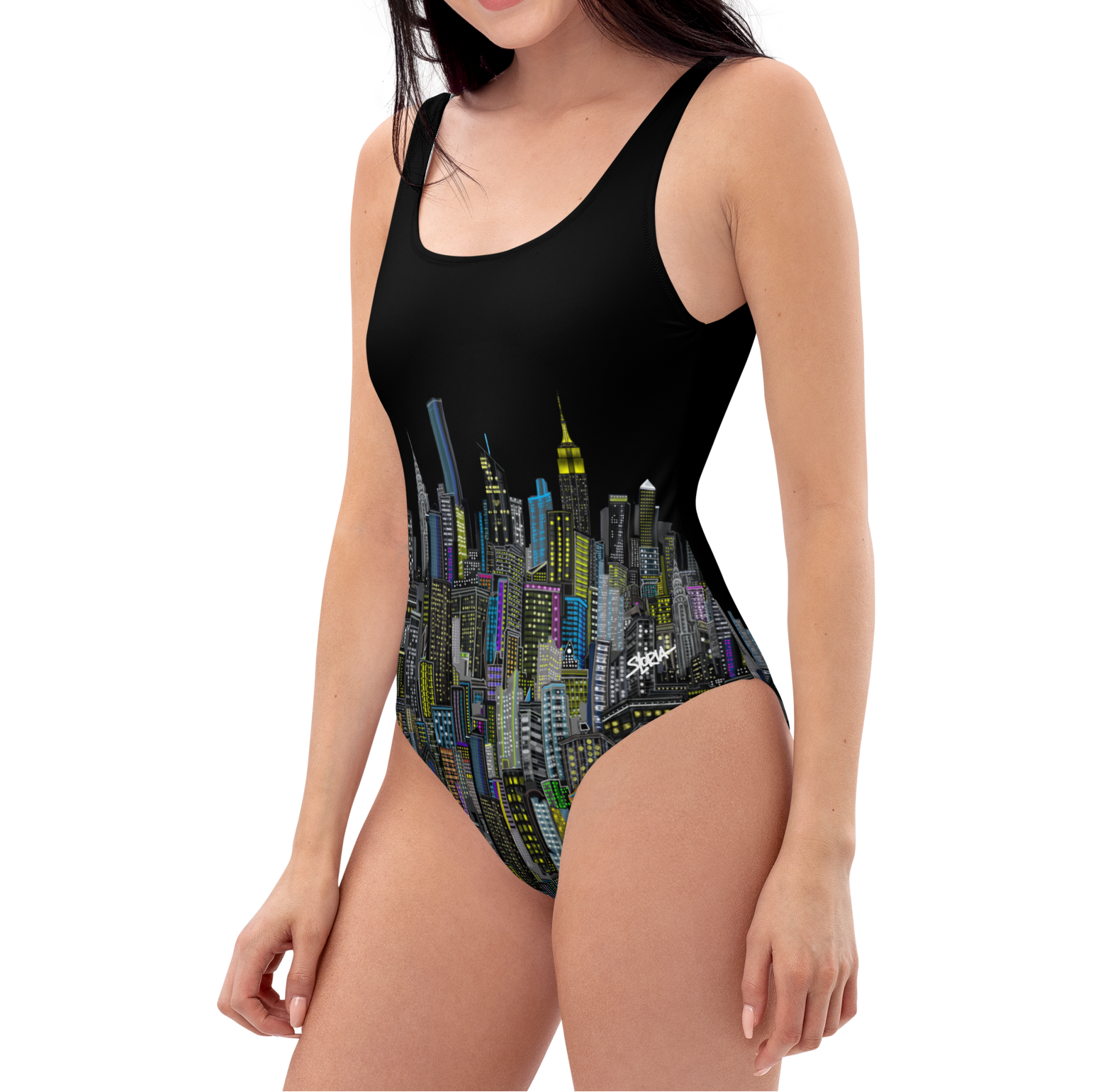 Woman wearing a black Loria NYC Art one-piece swimsuit with cityscape design on a white background