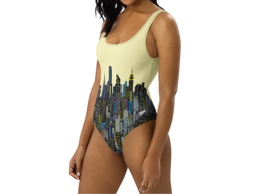 Woman wearing a one-piece swimsuit with Loria NYC Art cityscape design on a white background