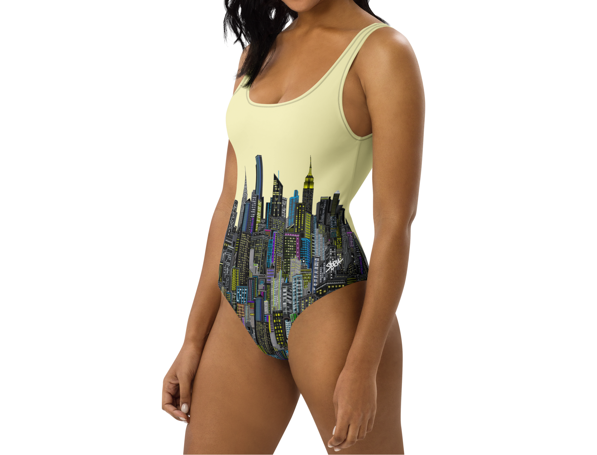 Woman wearing a one-piece swimsuit with Loria NYC Art cityscape design on a white background
