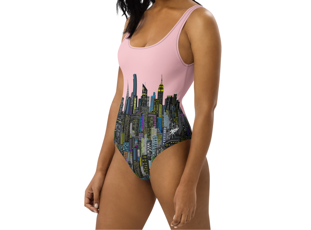 Woman wearing a pink one-piece swimsuit with cityscape Loria NYC Art design on a white background